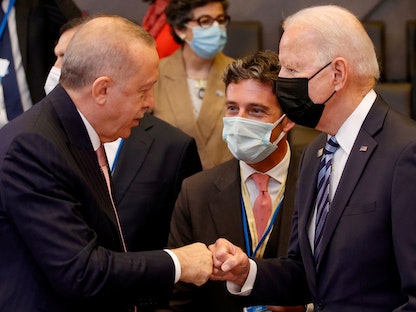 الرئيس التركي رجب طيب أردوغان يلقي التحية على نظيره الأميركي جو بايدن خلال قمة لحلف "الناتو" في بروكسل. 21 يونيو 2021 - REUTERS