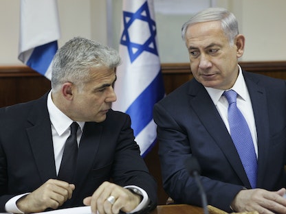 رئيس الوزراء الإسرائيلي الأسبق بنيامين نتنياهو ورئيس الوزراء الحالي يائير لبيد يحضران اجتماعاً للحكومة في القدس. 7 أكتوبر 2014  - REUTERS