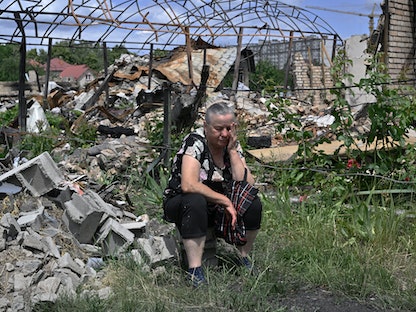 سيدة أوكرانية تنتظر الحصول على مساعدات في بلدة بوتشا شمال غربي العاصمة الأوكرانية كييف - 16 يونيو 2022 - AFP