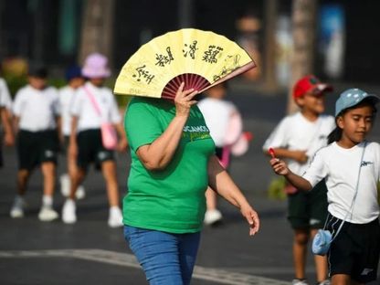 امرأة تستخدم مروحة يدوية لحماية وجهها من الشمس، وسط موجات جفاف وحر على مستوى المكسيك. 21 مايو 2024 - Reuters