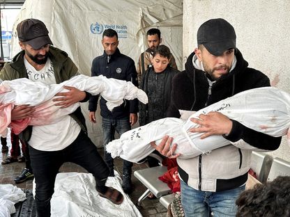 فلسطينيون يحملون جثث أطفالهم الذين قتلتهم إسرائيل في غارات على منازلهم في رفح بجنوب قطاع غزة. 13 ديسمبر 2023 - Reuters