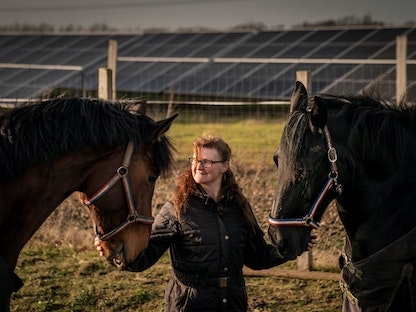 سيدة من السكان المحليين تقف مع خيولها في قرية جنوبي الدنمارك. 21 فبراير 2023 - REUTERS