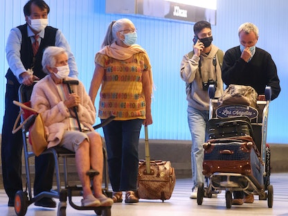 مسافرون في محطة توم برادلي الدولية بعد وصولهم إلى الولايات المتحدة في مطار لوس أنجلوس بولاية كاليفورنيا - 1 ديسمبر 2021  - AFP