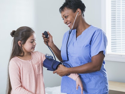 ممرضة تقيس ضغط الدم لطفلة - Getty Images