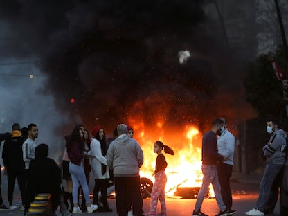 متظاهرون بمدينة صيدا يتجمعون قرب الإطارات المحترقة خلال احتجاج على هبوط سعر صرف الليرة اللبنانية وازدياد الصعوبات الاقتصادية - 8 مارس 2021 - REUTERS
