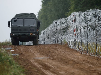 مركبة بجوار سياج بناه الجيش البولندي على الحدود بين بولندا وبيلاروسيا - 26 أغسطس 2021 - REUTERS
