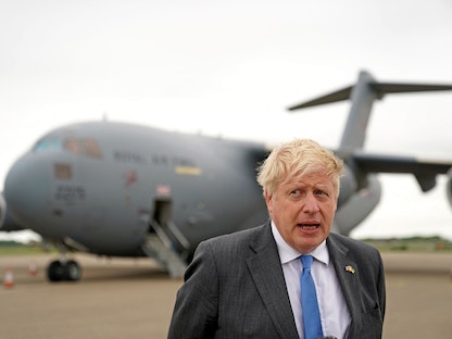 رئيس الوزراء البريطاني بوريس جونسون يتحدث إلى صحافيين في قاعدة "بريز نورتون" الجوية غرب لندن بعد عودته من كييف- 18 يونيو 2022 - AFP