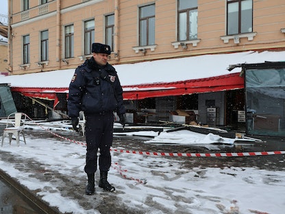 ضابط شرطة روسي يقف أمام المقهى الذي تعرض لانفجار أودى بحياة مدون عسكري روسي، سان بطرسبرغ. 3 أبريل 2023 - REUTERS