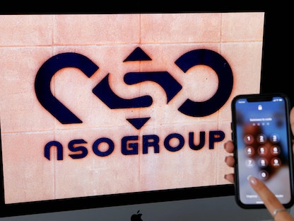 هاتف محمول قرب شعار شركة "إن إس أو" الإسرائيلية  المصنعة لبرنامج بيجاسوس للتجسس في مدينة ناتانيا الإسرائيلية- 9 فبراير 2022 - AFP
