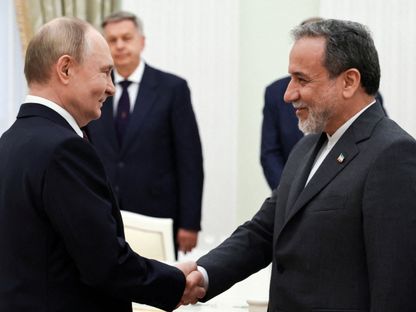 الرئيس الروسي فلاديمير بوتين يصافح وزير الخارجية الإيراني عباس عراقجي خلال اجتماع بالكرملين في موسكو. 23 يونيو 2025 - Reuters