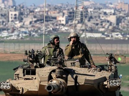 جنود إسرائيليون على دبابة بالقرب من الحدود مع غزة. 31 يناير 2024 - AFP