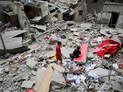 أطفال فلسطينيون يتفقدون موقع غارة إسرائيلية على منزل في رفح بجنوب قطاع غزة. 27 أبريل 2024 - Reuters