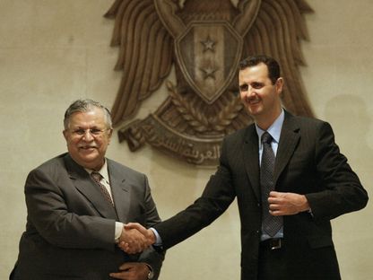 الرئيس السوري بشار الأسد (إلى اليمين) يصافح الرئيس العراقي آنذاك جلال طالباني خلال لقائهما في القصر الرئاسي في دمشق. 14 يناير 2007 - المجلة