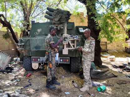 أفراد من الجيش السوداني يقفون بجانب مركبة عسكرية مدمرة بعد معركة مع قوات الدعم السريع في العاصمة الخرطوم، السودان. 25 مارس 2025 - Reuters