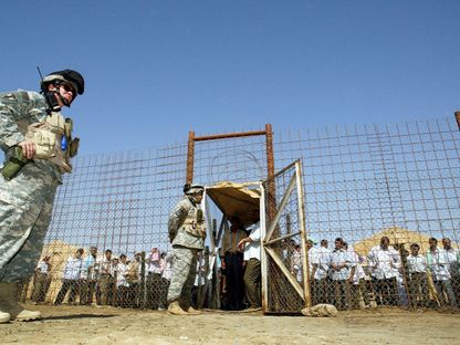 جنود أميركيون يشرفون على إطلاق سراح سجناء من سجن أبو غريب في العراق. 23 يونيو 2006 - AFP