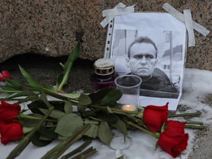 زهور بجوار صورة لزعيم المعارضة الروسية أليكسي نافالني في سانت بطرسبرغ بروسيا. 16 فبراير 2024 - رويترز