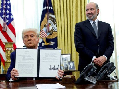 الرئيس الأميركي دونالد ترمب يحمل أمراً تنفيذياً لزيادة التعريفات الجمركية وإلى جواره وزير التجارة الأميركي هوارد لوتنيك في البيت الأبيض. 13 فبراير 2025 - REUTERS