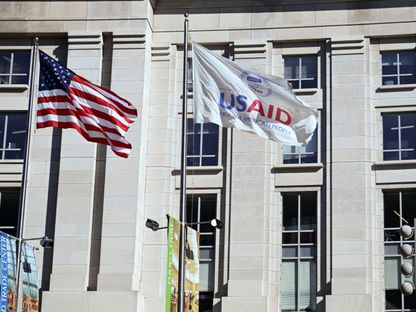 العلم الأميركي، وعلم الوكالة الأميركية للتنمية الدولية يرفرفان خارج مبنى الوكالة في العاصمة الأميركية واشنطن، 1 فبراير 2025 - Reuters