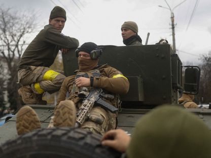 جنود أوكرانيون يجلسون على مركبات عسكرية وسط مدينة خيرسون في 16 نوفمبر 2022 - Reuters