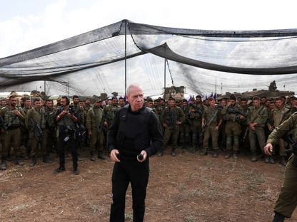 وزير الدفاع الإسرائيلي يوآف جالانت يتحدث إلى مجموعة من الجنود على الحدود مع قطاع غزة - 19 أكتوبر 2023 - Reuters