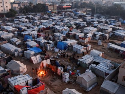 فلسطينيون نازحون إلى جنوب غزة يفككون خيامهم انتظاراً للسماح لهم بالعودة إلى منزلهم في شمال غزة بعد وقف إطلاق النار بدير البلح في وسط قطاع غزة. 25 يناير 2025 - REUTERS