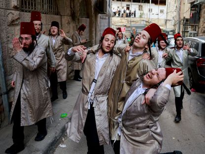 يهود متشددون من الحريديم يتجمعون أثناء احتفالهم بعيد المساخر اليهودي في حي ميا شعاريم بالقدس المحتلة. 25 مارس 2024 - Reuters