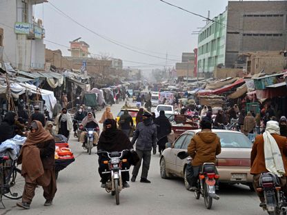 أفغان يسيرون في سوق مزدحم في قندهار، أفغانستان - 12 يناير 2023 - AFP