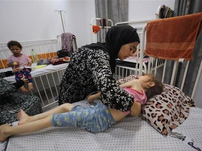 نسمة عياد تساعد ابنتها جنى عياد، التي تعاني من سوء التغذية، وفقًا للمسعفين، أثناء تلقيها العلاج في مستشفى بمدينة غزة، وسط أزمة جوع متفاقمة، 29 يوليو 2025. - Reuters