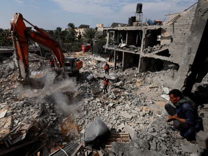 فلسطينيون يبحثون عن ضحايا تحت أنقاض منزل دمرته الغارات الإسرائيلية في خان يونس جنوب قطاع غزة. 16 أكتوبر 2023 - Reuters