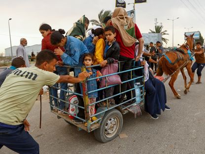 أطفال فلسطينيون مع أسرهم داخل عربة بدائية في رحلة النزوح من شمال غزة إلى جنوبها، 12 نوفمبر 2023 - Reuters