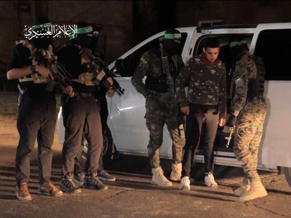 مقاتلون من كتائب عز الدين القسام الجناح العسكرية لحركة "حماس" خلال عملية لتبادل الأسرى مع إسرائيل. 30 نوفمبر 2023 - Reuters