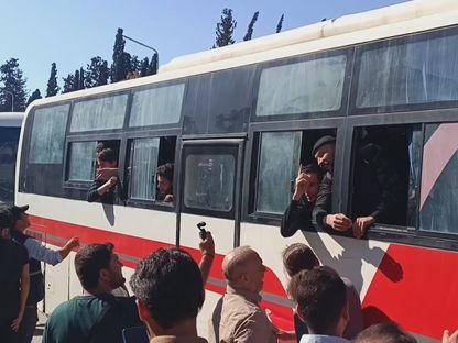 أسرى يطلون من نوافذ الحافلات بعد عملية تبادل بين الحكومة السورية وقوات سوريا الديمقراطية (قسد) 2 يونيو 2025 - "الشرق"