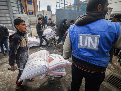 فلسطينيون يتسلمون مساعدات غذائية من مقر وكالة الأمم المتحدة لغوث وتشغيل اللاجئين الفلسطينيين في رفح جنوبي القطاع. 26 يناير 2024 - AFP