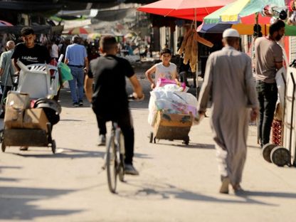 فلسطينيون في سوق بمدينة غزة شمال القطاع بينما يتواصل القصف الإسرائيلي والغارات. 12 يونيو 2024 - AFP