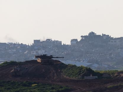 دبابات إسرائيلية تتحرك على الحدود مع قطاع غزة وفي الخلفية عشرات المباني المدمرة. 21 فبراير 2024 - Reuters