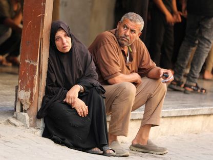 رجل وامرأة جالسان قرب مستشفى الأهلي العربي المعمداني في مدينة غزة بعد غارة جوية إسرائيلية. 25 يونيو 2025 - reuters