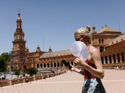 امرأة تسير خلال موجة حر في مدينة إشبيلية الإسبانية - 11 يونيو 2022 - REUTERS