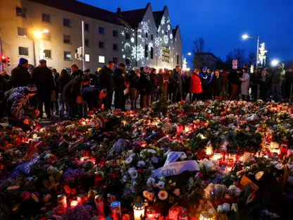 أشخاص يضعون باقات الزهور والشموع والألعاب بالقرب من موقع حادثة الدهس في ماجديبورج بألمانيا. 21 ديسمبر 2024 - Reuters