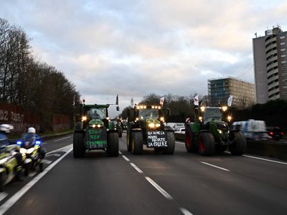 مزارعون فرنسيون يقودون الجرارات باتجاه سوق رونجيس بعد تجاوز حاجز للشرطة، خلال احتجاج على الطريق السريع A6 بالقرب من لونججومو، جنوب باريس، في 29 يناير 2024 - AFP
