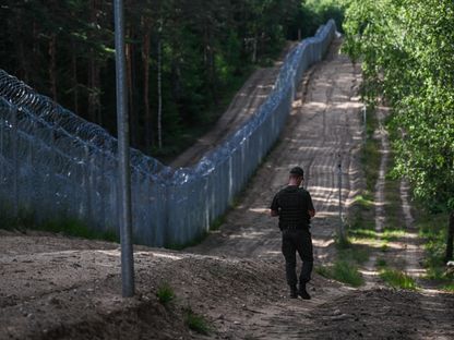 ضباط حرس الحدود الليتوانيون يقومون بدوريات بجوار السياج المعدني على الحدود الليتوانية البيلاروسية . 10 يوليو 2023 - AFP
