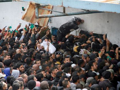 فلسطينيون يتجمعون لتلقي مساعدات خارج مستودع للأونروا في مدينة غزة. 18 مارس 2024 - Reuters