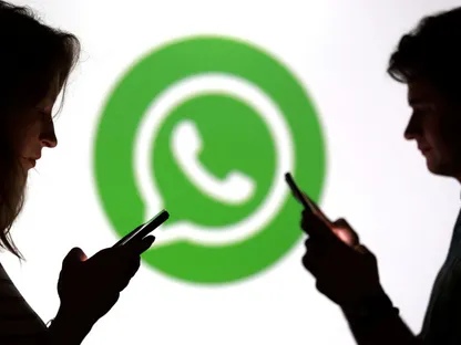 شعار خدمة واتساب تظهر في الخلفية وأمامها يقف اثنين من المستخدمين يحملون هواتفهم الذكية. 11 سبتمبر 2025 - REUTERS - REUTERS