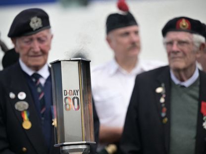 قدامى المحاربين البريطانيين يقفون خلف شعلة إحياء ذكرى إنزال نورماندي بمناسبة الذكرى الـ 80 للحرب العالمية في فرنسا. 4 يونيو 2024 - AFP