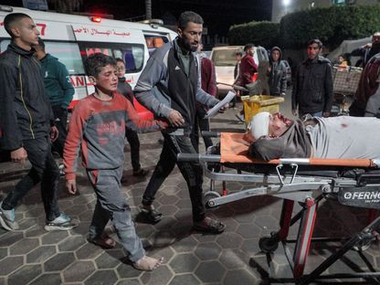 طفل فلسطيني يرافق قريباً له خلال نقله لتلقي العلاج في مستشفى شهداء الأقصى بعد استهداف منزلهم في دير البلح وسط قطاع غزة. دير البلح، فلسطين. 12 مارس 2024 - AFP