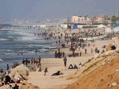 فلسطينيون يحتشدون على الشاطئ أملا في الحصول على مساعدات تسقطها طائرات على غزة. 27 فبراير 2024 - رويترز