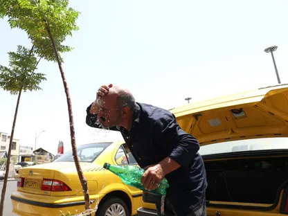 سائق تاكسي إيراني يرش الماء على وجهه خلال موجة حر في طهران، إيران. 2 أغسطس 2023 - Reuters