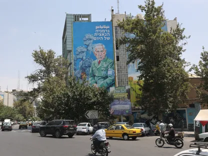 لوحة إعلانية عليها رسم كاريكاتوري لرئيس الوزراء الإسرائيلي بنيامين نتنياهو على مبنى في طهران بإيران وقد كتب عليها بالعبرية "ألمانيا النازية اليوم" في إشارة إلى جرائم إسرائيل في غزة. 10 أغسطس 2025 - REUTERS
