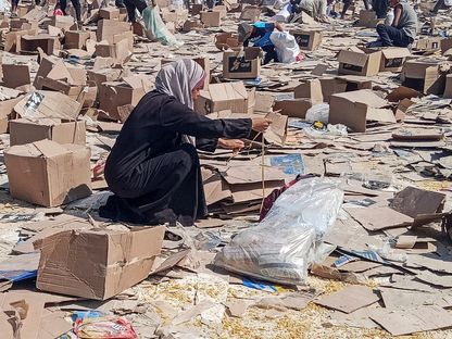 فلسطينية تجمع ما تبقى من إمدادات الإغاثة من مركز مؤسسة غزة الإنسانية في رفح جنوب القطاع الفلسطيني. 5 يونيو 2025 - REUTERS