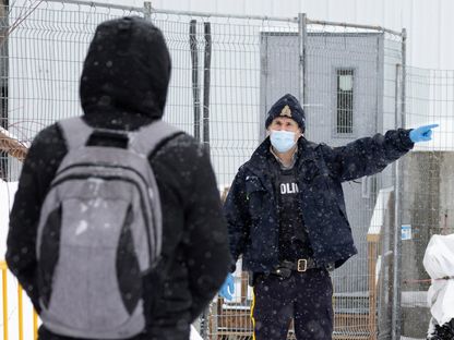 ضابط من شرطة الخيالة الملكية الكندية (RCMP) يأمر طالب لجوء بتغيير مساره أثناء اقترابه من الحدود للعبور إلى كندا من الولايات المتحدة. 28 فبراير 2023 - REUTERS