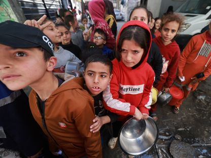 أطفال فلسطينيون ينتظرون الحصول على طعام في رفح جنوبي قطاع غزة والتي نزح إليها اكثر من مليون شخص بسبب الغارات الإسرائيلية والقصف المكثف على القطاع. 5 مارس 2024 - AFP